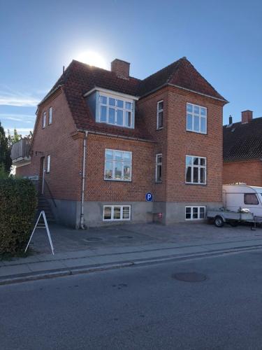 a brick house with a van parked in front of it at Køge Bed & Kitchen - Rooms in Køge