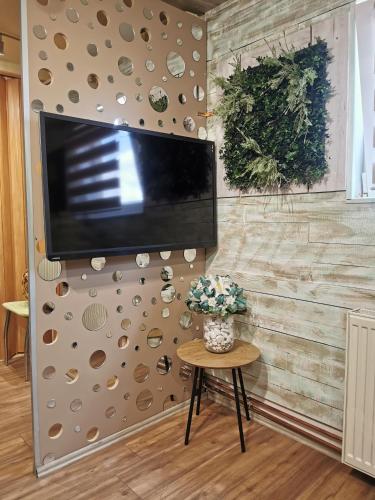 a flat screen tv hanging on a wall with a table at URBAN Life STYLE in Zaječar