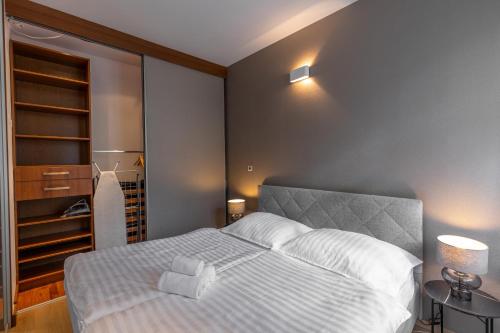 a bedroom with a white bed and a refrigerator at Laurinska modern apartment in direct centrum of Bratislava, Air-condition in Bratislava