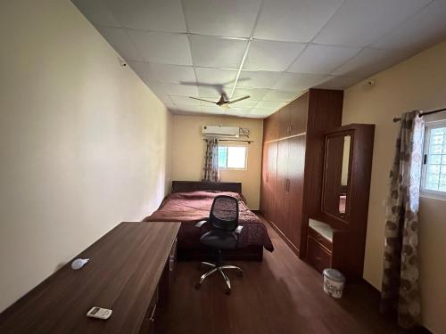 een slaapkamer met een bed en een stoel erin bij Parvati Home Stay in Mysore