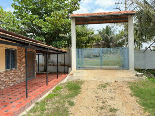 un garage con cancello blu di fronte a una casa di Parvati Home Stay a Mysore