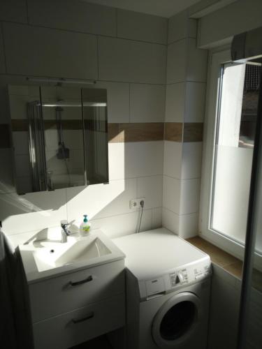 ein Badezimmer mit einem Waschbecken und einer Waschmaschine in der Unterkunft Großes Haus in Zossen