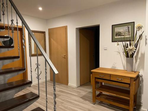 a room with a staircase and a table with a vase of flowers at Casa Angres - Lüneburger Heide in Königsmoor