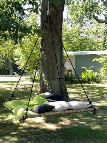a swing around a tree with pillows on it at Casa Angres - Lüneburger Heide in Königsmoor