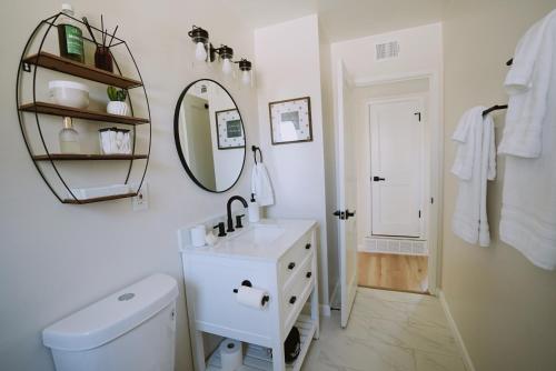 a white bathroom with a sink and a mirror at The White House-NEWLY REMODELED & CENTRALLY LOCATED! in Albuquerque