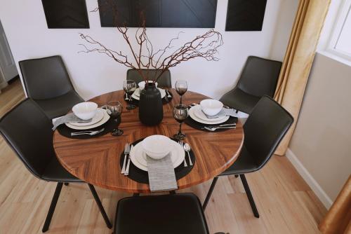 a wooden table with black chairs and a dining room at Centrally Located! Remodeled! Huge Backyard! The White House in Albuquerque