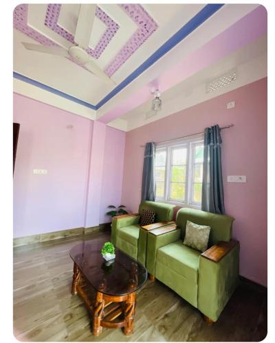 a living room with a green couch and a table at Renade Leisure Stay in Agartala
