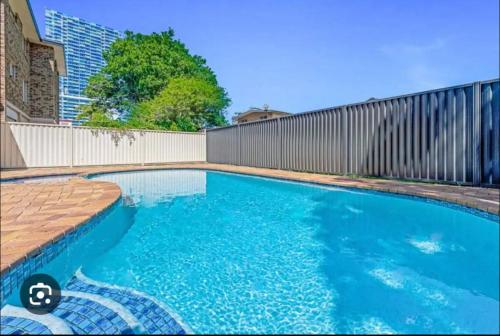 a swimming pool in front of a fence at Penthouse with private Rooftop on the Broadwater in Gold Coast