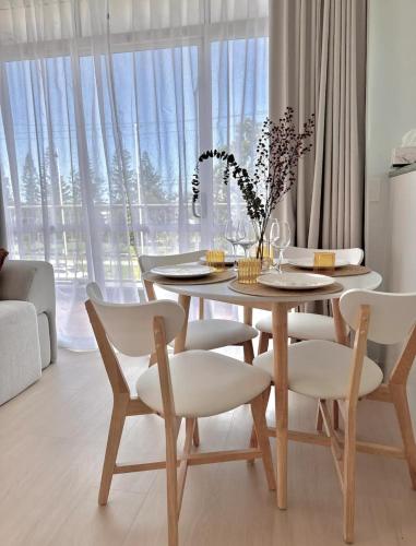 a dining room with a table and white chairs at Penthouse with private Rooftop on the Broadwater in Gold Coast
