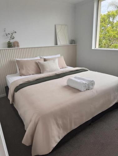 a large white bed with two rolled towels on it at Penthouse with private Rooftop on the Broadwater in Gold Coast
