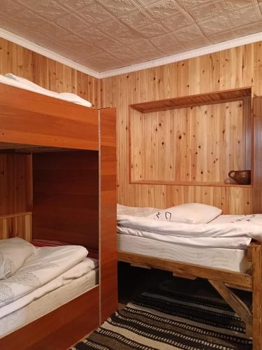 2 beliches num quarto com paredes de madeira em Pamir lodge em Khorog