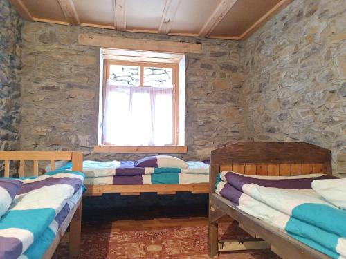 Duas camas num quarto com uma janela em Pamir lodge em Khorog