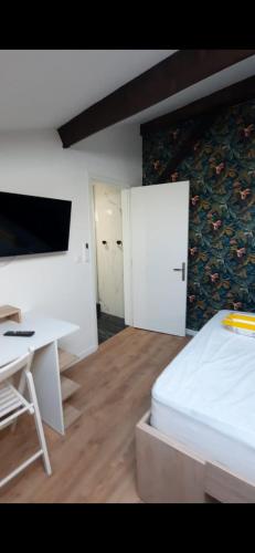 a bedroom with a bed and a desk and a table at Appartement 2 pièces à 5 minutes de la plage in Saint-Laurent-du-Var