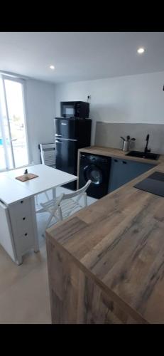 uma cozinha com uma mesa e uma bancada em Appartement 2 pièces à 5 minutes de la plage em Saint-Laurent-du-Var