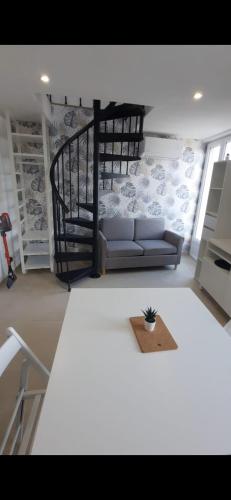 a living room with a couch and a staircase at Appartement 2 pièces à 5 minutes de la plage in Saint-Laurent-du-Var