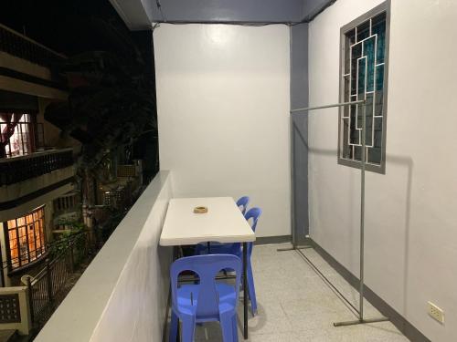 a table and two blue chairs in a room at Romblon Transient House 2nd Floor in Romblon