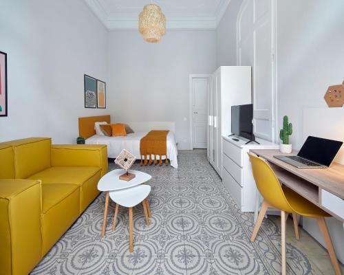 uma sala de estar com um sofá e uma cama em GIRONA em Barcelona