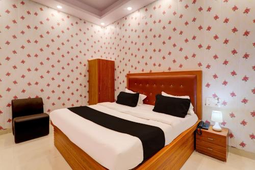 1 dormitorio con 1 cama grande con papel pintado de color rojo en OYO Shobhika Inn, en Lucknow