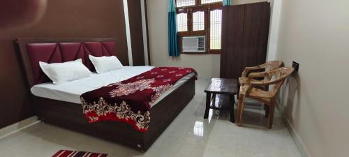 a bedroom with a bed and a chair in it at OYO Home Anandi Homestay in Ayodhya