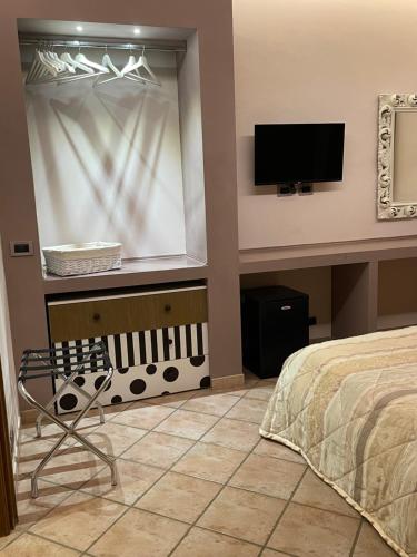 a bedroom with a bed and a flat screen tv at VILLA MARIPOSA in Nettuno