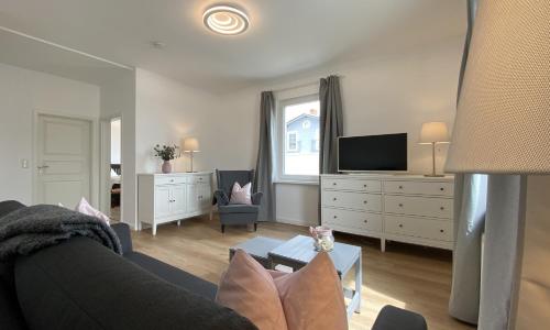 a living room with a couch and a tv at Villa Rosalie Sassnitz in Sassnitz