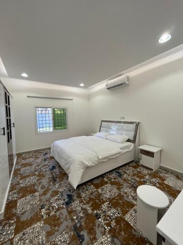 een slaapkamer met een bed en een tegelvloer bij شاليه الليوان in Al Bukayriyah