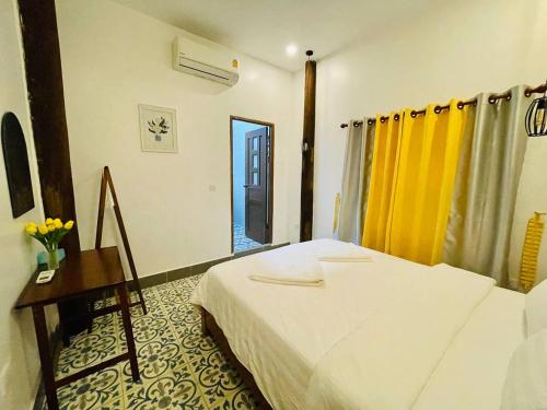a bedroom with a bed and a table and a mirror at HOLY VILLA 4rooms, 5beds, 6baths, 1KCH, 1LR riverside private villa in Kampot
