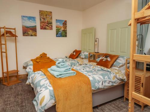 a bedroom with two beds and a bunk bed at Wells Cottage in Holmfirth