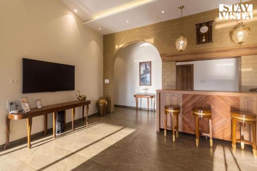 a large room with a tv on the wall at StayVistas Nyra Farms - Hill-view villa with Pool, Indoor & Outdoor games, & Lawn with Gazebo in Wada