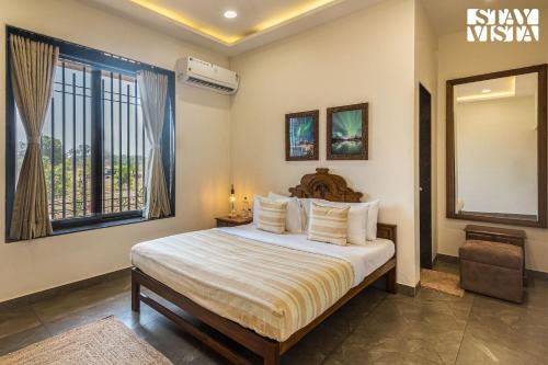 a bedroom with a bed and a large window at StayVistas Nyra Farms - Hill-view villa with Pool, Indoor & Outdoor games, & Lawn with Gazebo in Wada