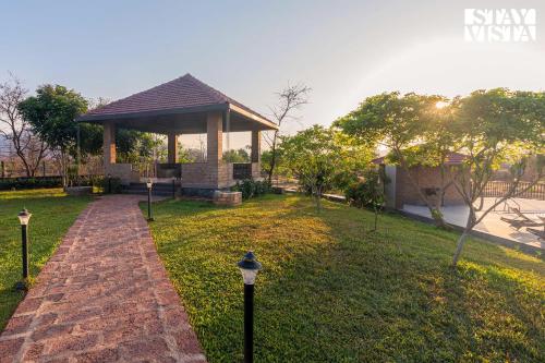 a gazebo in a park with a pathway at StayVistas Nyra Farms - Hill-view villa with Pool, Indoor & Outdoor games, & Lawn with Gazebo in Wada