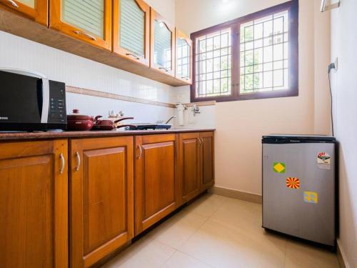 a kitchen with a refrigerator and a microwave at Elim Homestay Fort Kochi in Cochin