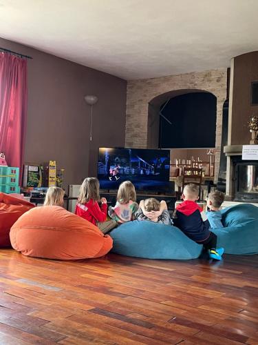a group of children sitting on pillows in a living room at Orlik by Good Spot in Duszniki Zdrój