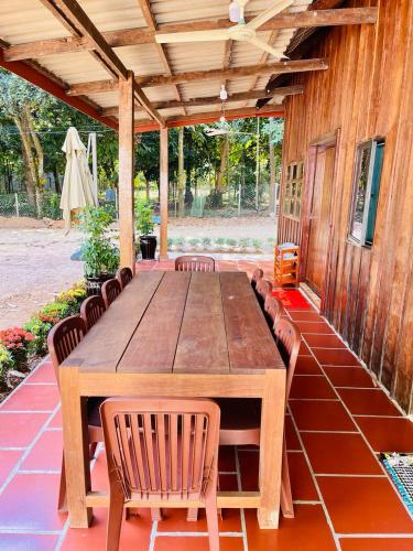 uma mesa de madeira e cadeiras num pátio em Wooden house 2 Beds 1 BR 1KCH 1 Dinning Area em Kampot