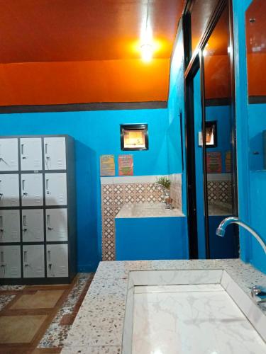 a bathroom with a blue wall and a sink at Adriana's Place Tropical Guesthouse in Panglao