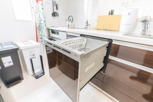 a kitchen with a sink and a dishwasher at Tokyo Private House 大塚の宿 in Tokyo