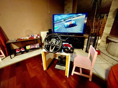 a living room with a tv with a car on the screen at Orlik by Good Spot in Duszniki Zdrój