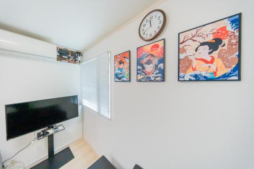 a living room with a clock on the wall at Tokyo Private House 大塚の宿 in Tokyo
