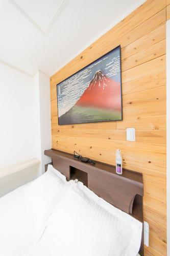 a bedroom with a television on a wooden wall at Tokyo Private House 大塚の宿 in Tokyo