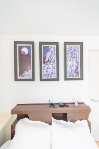 a living room with three pictures on the wall at Tokyo Private House 大塚の宿 in Tokyo