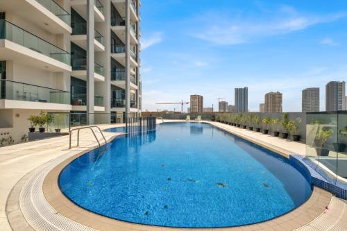 a large swimming pool on the roof of a building at Stylish 2BR for 6 with King Beds, Pool, Gym in JVC in Dubai