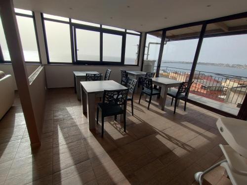 a restaurant with tables and chairs on a balcony at Nick & Santo's Holiday Homes B&B in Giardini Naxos