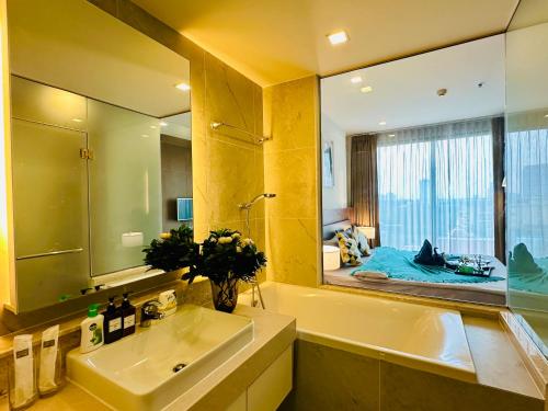 チェンマイにあるThe Astra Condo Chiang Maiの洗面台と大きな鏡のあるバスルーム