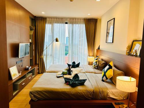 チェンマイにあるThe Astra Condo Chiang Maiのベッドが2つと大きな窓がある寝室