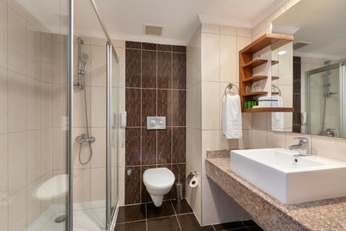 a bathroom with a toilet and a sink and a shower at Greenwood Kemer Resort in Kemer
