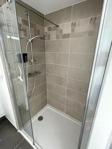 une douche avec une porte vitrée dans une salle de bain dans l'établissement Studio avec balcon et parking!, à Puilboreau