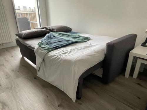 - un lit sans lit dans une chambre avec une table dans l'établissement Studio avec balcon et parking!, à Puilboreau