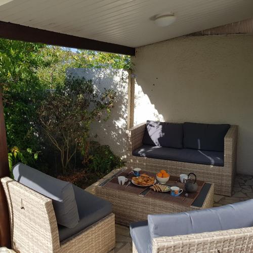 d'une terrasse avec un canapé et une table. dans l'établissement Maison complète Cap d'Agde au calme avec jardin, au Cap d'Agde