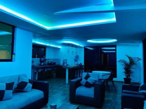 sala de estar con sofá y luz azul en Villa Mirlo – Escondite de Lujo en Quito en Quito