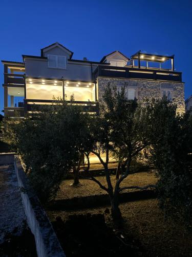 Una casa con luces en el costado. en Apartments Leona, en Rogoznica